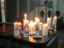 Bunte Kerzen auf dem Taufstein